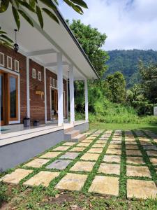 a house with a stone walkway outside at nyoman sekumpul house in Sudaji