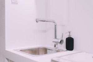 lavabo con dispensador de jabón junto a un aseo en Minimalist Loft 8 Namba Compact Studio and Gym MA801, en Osaka