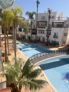 卡萨布兰卡Apartment in a beachfront complex的享有棕榈树和建筑的游泳池的顶部景致