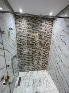 卡萨布兰卡Apartment in a beachfront complex的带淋浴的浴室，配有石墙