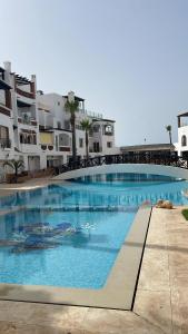 卡萨布兰卡Apartment in a beachfront complex的建筑物前的一个大型游泳池