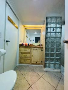 a bathroom with a sink and a toilet and a mirror at Oceanview Casita 1BR 1 5BA with pool in Rosarito