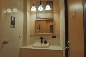 a bathroom with a sink and a mirror at Brightwood Hotel & Residences in Manila