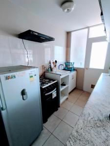 a small kitchen with a refrigerator and a sink at Tu Hogar en Quilpué in Quilpué +4 photos