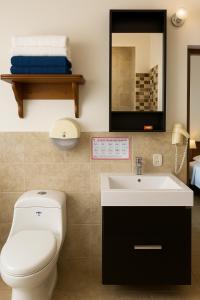 a bathroom with a toilet and a sink and a mirror at Hosteria La Real in Santa Fe de Antioquia +13 photos