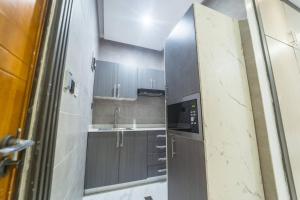 Una pequeña cocina con fregadero y microondas. en D8/Airport Proximity Comfort, en Otele