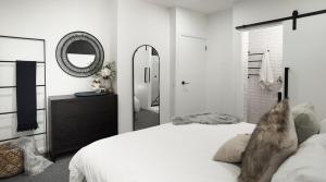 Un dormitorio con una cama blanca y un espejo. en PISTE LUXURY CHALET - Lake Crackenback Resort, en Crackenback 53 fotos más