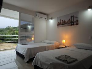una camera con due letti e una finestra con vista di Suite Privada, Aire Acondicionado, Balcon y Piscina a Villeta