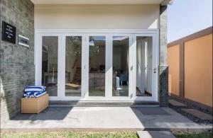 a sliding glass door of a house with a chair at Central Seminyak Private 3 Bedroom Villa Roshi in Seminyak
