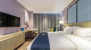 ein Hotelzimmer mit einem Bett und einem Flachbildfernseher in der Unterkunft Echarm Hotel Nanning Baisha Avenue Tingjiang Interchange BBK in Nanning