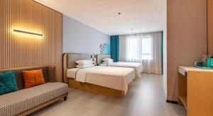 une chambre d'hôtel avec deux lits et un canapé dans l'établissement City Comfort Inn Wuhan Pangxiejia Metro Station, à Wuhan 185 autres photos