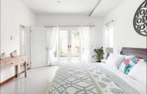 a white bedroom with a large bed and a desk at Central Seminyak Private 3 Bedroom Villa Roshi in Seminyak +39 photos