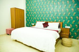 una camera con un letto bianco e una parete verde di Vizata Hotel And Resort a Jaipur Altre 46 foto