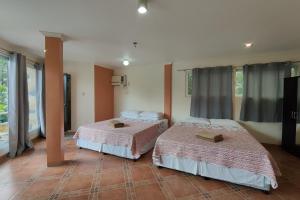 two beds sitting in a room with windows at Elicon Suites Resort Bohol near City Center in Tagbilaran City +76 photos