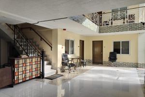 a living room with stairs and a table and chairs at Elicon Suites Resort Bohol near City Center in Tagbilaran City