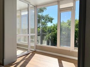an empty room with large windows with a view at Двухкомнатная квартира в центре in Pavlodar