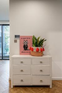 a white dresser with a potted plant on top of it at LUMIERE RIVERSIDE LUXURY APARTMENT 5STar in Ho Chi Minh City