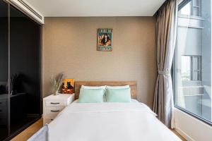 a bedroom with a large bed and a window at LUMIERE RIVERSIDE LUXURY APARTMENT 5STar in Ho Chi Minh City