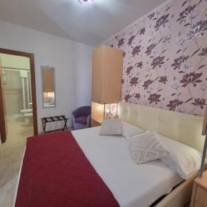 a bedroom with a white bed with a red blanket at Residence Maresol in Vieste
