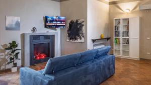 a blue couch in a living room with a fireplace at Relais Della Corte in Sala Baganza