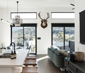 Una cocina y una sala de estar con un sofá y una mesa. en PISTE LUXURY CHALET - Lake Crackenback Resort, en Crackenback