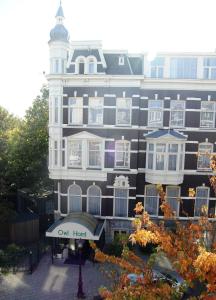 un gran edificio con un cartel delante en Owl Hotel en Ámsterdam