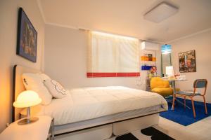 a bedroom with a bed and a table and a chair at Coco Bloom Sinsa in Seoul