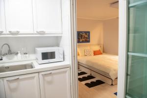 a small kitchen with a bed and a microwave at Coco Bloom Sinsa in Seoul