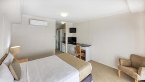 a bedroom with a bed and a desk and a chair at Capella Coach Inn in Capella