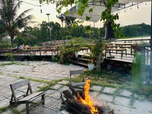 a fire pit in a park with benches and tables at Bến Hồ Homestay in Xã Gia Tân