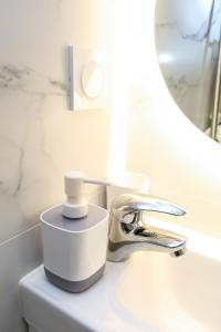 un lavandino del bagno con un rubinetto e uno specchio di Cozy studio in Nice Désambrois a Nizza