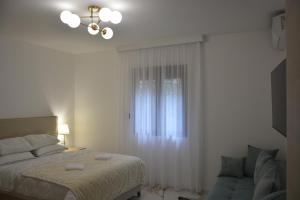 a bedroom with a bed and a window and a couch at Stunning Sea View - Brand New Apartments in Kotor
