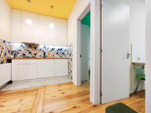 a kitchen with white cabinets and wood floors at Guest House Bolnisi - Duplex apartment in Bolnisi