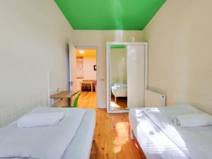 two beds in a room with a green ceiling at Guest House Bolnisi - Duplex apartment in Bolnisi