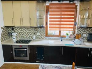 a kitchen with a sink and a stove at Romeo apt with private garden in Korçë