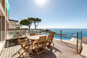 a wooden deck with a table and chairs and the ocean at Rocamar in Cabo de Palos