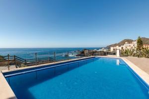 a swimming pool with a view of the ocean at Rocamar in Cabo de Palos