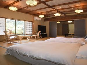 una camera da letto con due letti, un tavolo e delle sedie di Wakamatsu HakoneYugawara a Yugawara