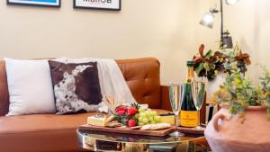 a living room with a couch with a table with fruits and wine bottles at Secret Garden in Bowral