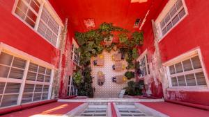 a red building with windows and plants on the wall at Hôtel Amphithéâtre in Arles