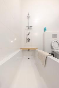 a white bathroom with a toilet and a sink at הבית in Hagoshrim
