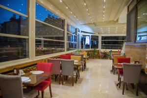 ein Restaurant mit Tischen und Stühlen und Fenstern in der Unterkunft Kayı Hotel in Fethiye