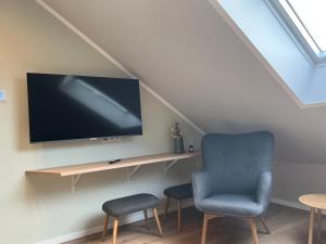 a room with a tv and a chair and a table at Lippischer-Traum 1 in Detmold