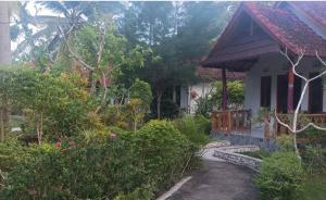a house with a walkway leading to a garden at Dangin Kubu Pedoman in Toyapakeh