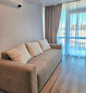Una sala de estar con un sofá y una ventana grande. en Šeimos apartamentai, Mano Šventovė, en Palanga