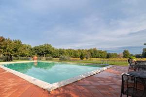 Una piscina con una mesa y sillas en un patio. en Villa In The Farmhouse With Pool In Tuscany, en Bucine