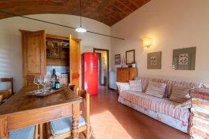 Una sala de estar con un sofá y un refrigerador rojo. en Villa In The Farmhouse With Pool In Tuscany, en Bucine