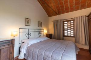 Un dormitorio con una cama grande y una ventana. en Villa In The Farmhouse With Pool In Tuscany, en Bucine 3 fotos más