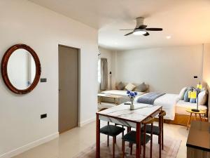 a bedroom with a bed and a table and a mirror at Indigo Studio 2 mins from SRT Wat Samien Nari in Bangkok +5 photos