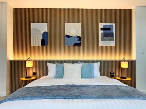 a bedroom with a bed and some pictures on the wall at Indigo Studio 2 mins from SRT Wat Samien Nari in Bangkok